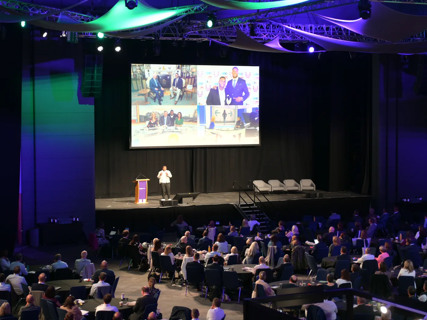 Omar Sharif speaking to a full conference hall, with his TV appearances on the big screen